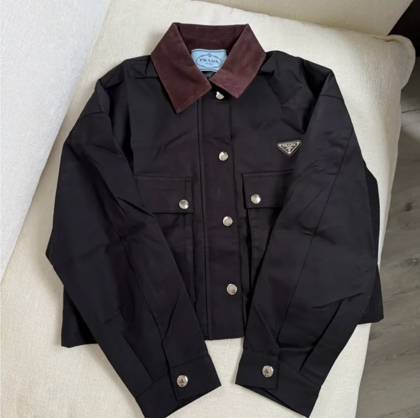 Black jacket with brown collar on a white surface